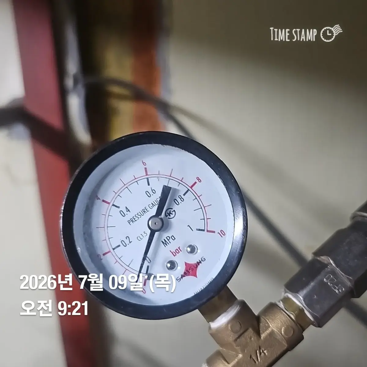 배관에 설치된 압력계 눈금을 확인하는 근접 사진